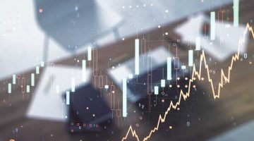Growing financial graph on desktop background with laptop. Multi exposure. Stock market concept